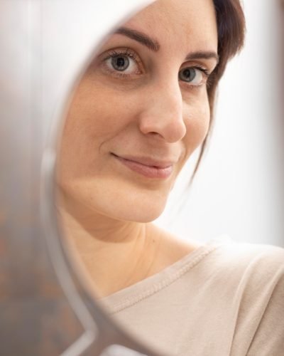 retrato-de-mulher-se-olhando-no-espelho-apos-o-tratamento-com-microblading